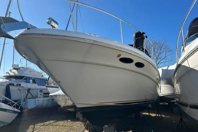 Slide: The Image of 2001 Sea Ray 340 Sundancer boat on dry dock, side view under clear blue sky. - 4