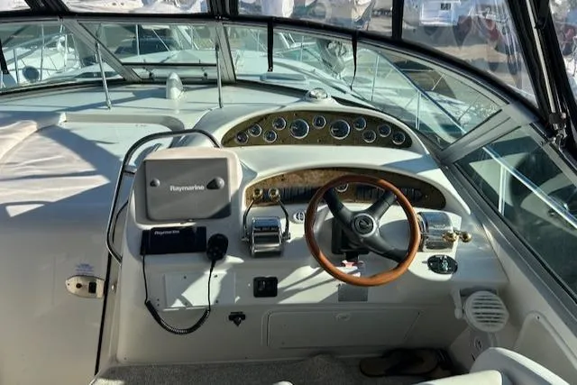 Slide: The Image of 2001 Sea Ray 340 Sundancer helm with Raymarine navigation, wooden steering wheel, and instrument panel. - 7