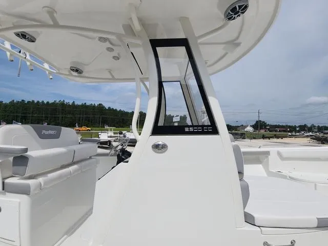 Slide: The Image of 2025 Parker 2600 CC boat interior with seating and control panel, under a clear sky. - 11