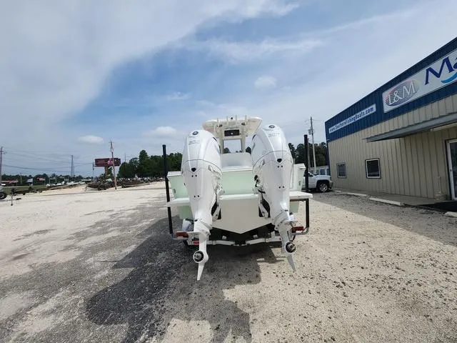 Slide: The Image of 2025 Parker 2600 CC boat with dual outboard motors in a parking lot. - 6