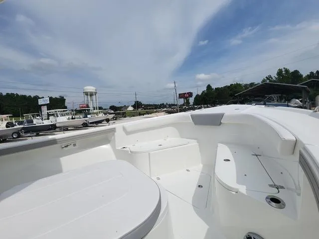 Slide: The Image of 2025 Parker 2600 CC boat with spacious deck under a clear sky. - 9