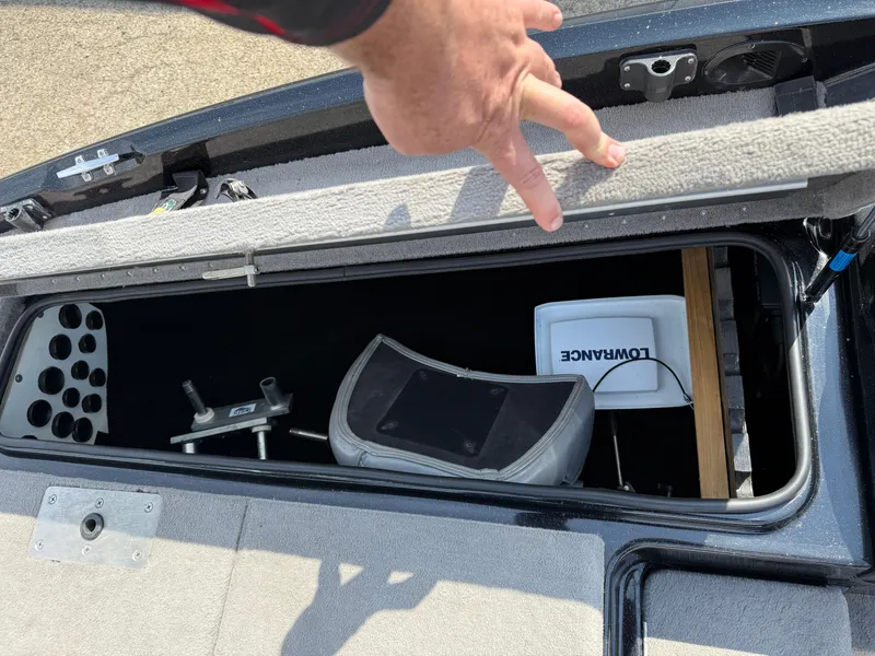 Slide: The Image of 2009 Triton 18 Explorer boat storage compartment with Lowrance equipment and fishing gear. - 12