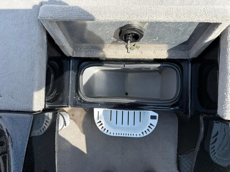 Slide: The Image of 2009 Triton 18 Explorer boat storage compartment with open lid and key lock. - 15