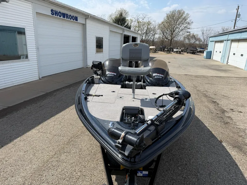 Slide: The Image of 2009 Triton 18 Explorer boat parked outside a showroom on a sunny day. - 2