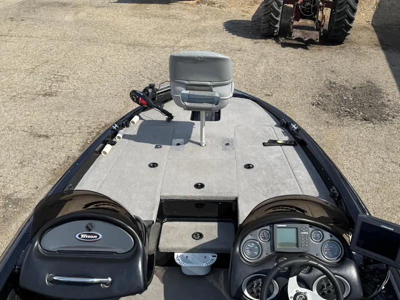 Slide: The Image of 2009 Triton 18 Explorer boat interior with steering console and seating. - 21