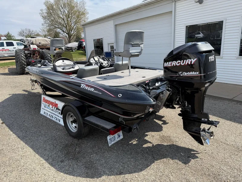 Slide: The Image of 2009 Triton 18 Explorer boat with Mercury 115 engine, parked outside a garage. - 7