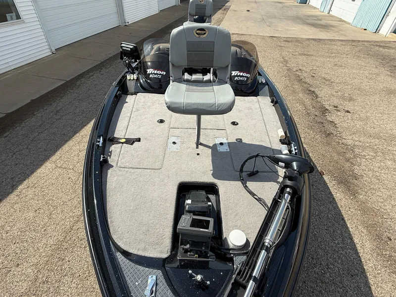 Slide: The Image of 2009 Triton 18 Explorer fishing boat with seating and equipment on a paved surface. - 8