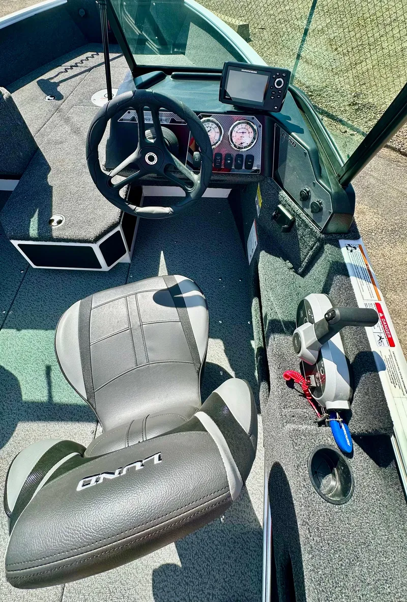 Slide: The Image of 2025 Lund 1775 Adventure Sport boat interior with steering wheel and control panel. - 10