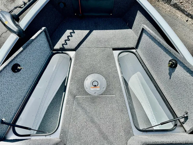 Slide: The Image of 2025 Lund 1775 Adventure Sport boat interior with storage compartments and gray carpeting. - 13