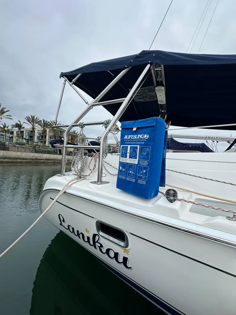 Slide: The Image of 2007 Hunter 44 Deck Salon sailboat docked, featuring a blue Lifesling on the deck. - 11