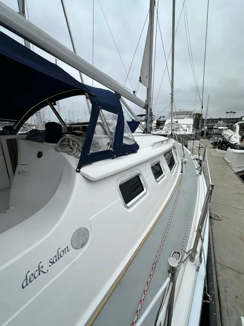 Slide: The Image of 2007 Hunter 44 Deck Salon sailboat docked at marina, featuring sleek design and spacious deck. - 13