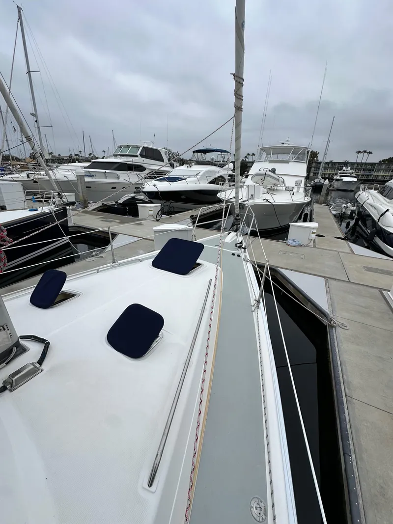 Slide: The Image of 2007 Hunter 44 Deck Salon sailboat docked at a marina, surrounded by other boats. - 15
