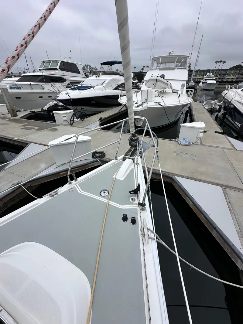 Slide: The Image of 2007 Hunter 44 Deck Salon sailboat docked among other boats in a marina. - 16