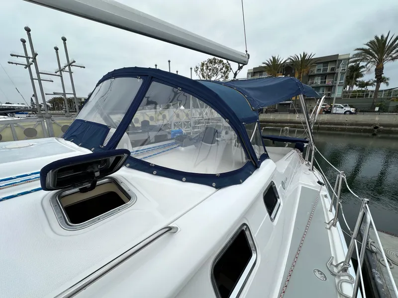 Slide: The Image of 2007 Hunter 44 Deck Salon sailboat with blue canopy docked at marina. - 21