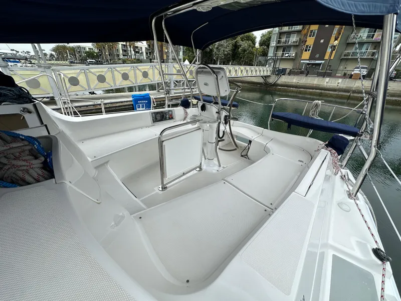 Slide: The Image of 2007 Hunter 44 Deck Salon yacht cockpit with seating and steering wheel, docked in marina. - 22