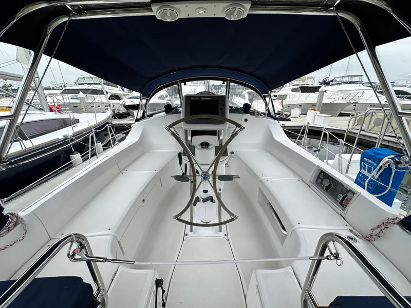 Slide: The Image of 2007 Hunter 44 Deck Salon yacht cockpit with blue canopy, docked at marina. - 25