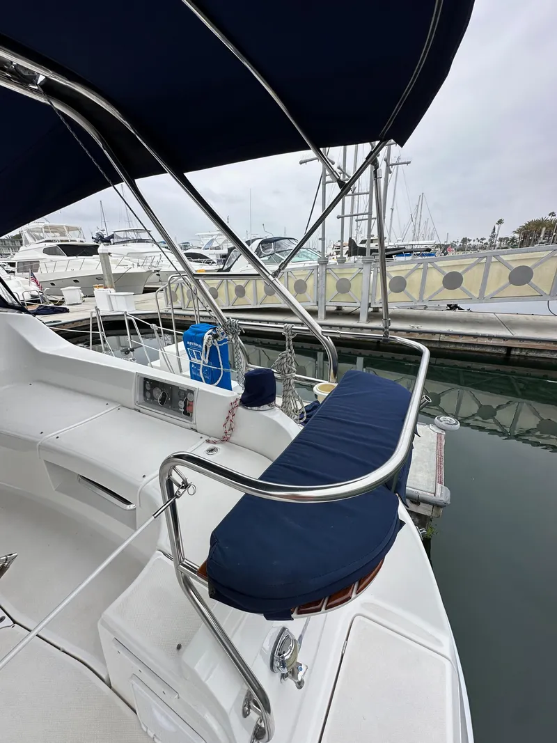 Slide: The Image of 2007 Hunter 44 Deck Salon sailboat with blue seating, docked at a marina. - 27