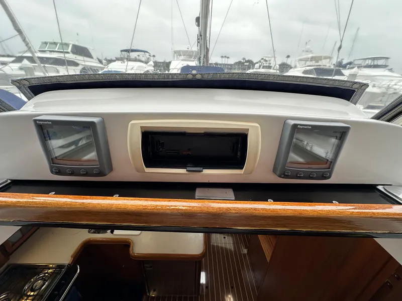 Slide: The Image of 2007 Hunter 44 Deck Salon cockpit with navigation instruments and marina view. - 37