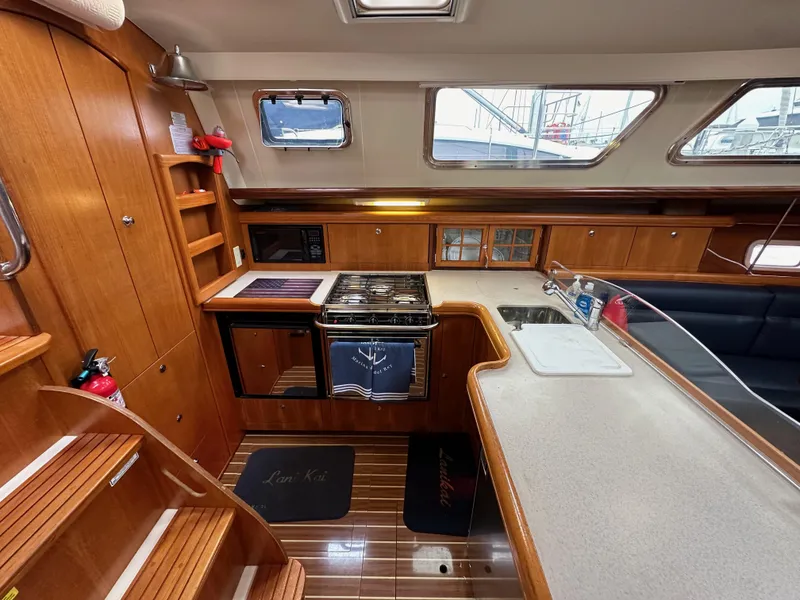 Slide: The Image of 2007 Hunter 44 Deck Salon interior with wood cabinetry, kitchen, and seating area. - 42