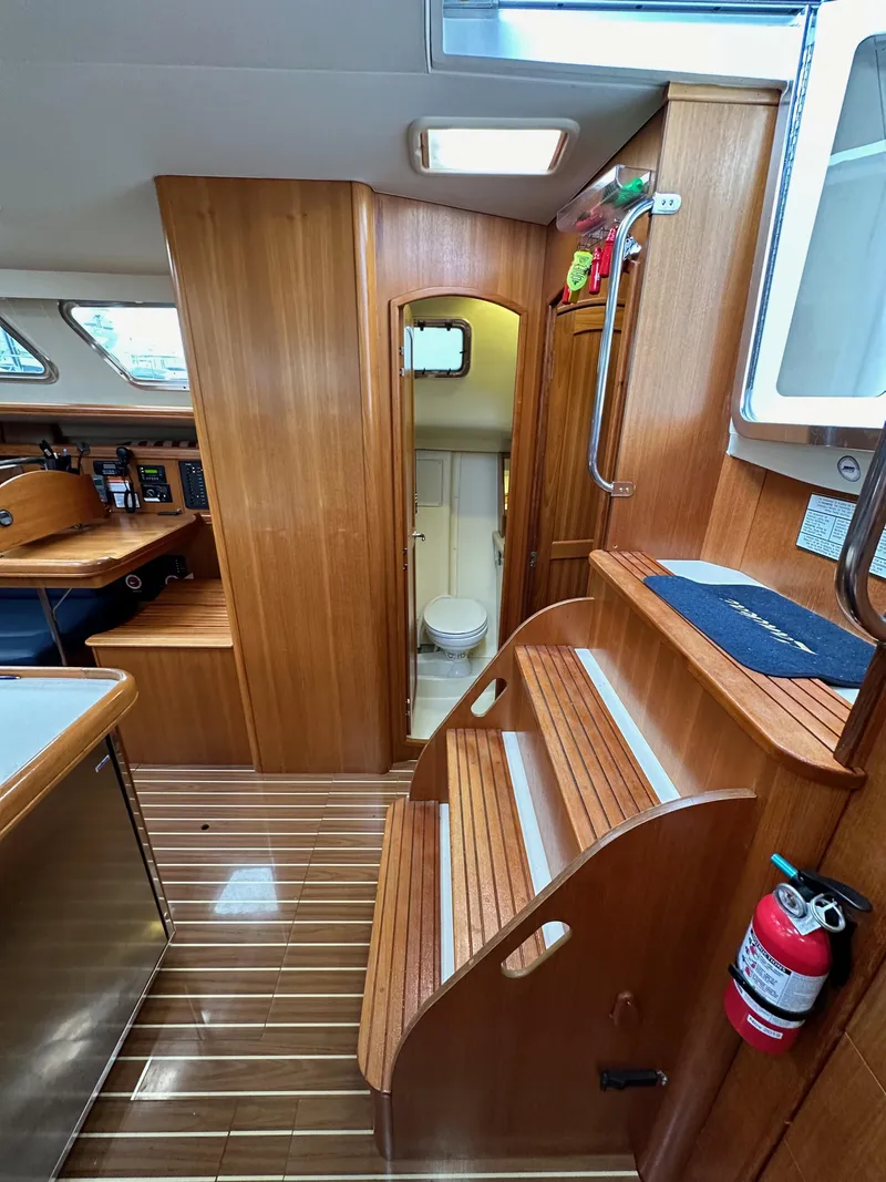 Slide: The Image of 2007 Hunter 44 Deck Salon interior with wood finish and compact bathroom. - 49
