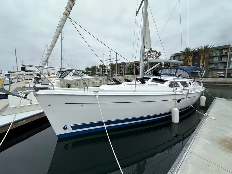 Slide: The Image of 2007 Hunter 44 Deck Salon sailboat docked at marina, overcast sky. - 5