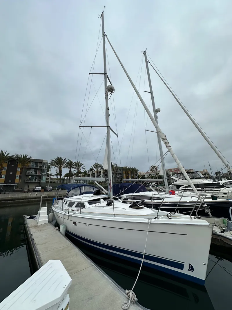 Slide: The Image of 2007 Hunter 44 Deck Salon sailboat docked at marina under cloudy sky. - 7