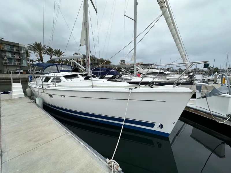 Slide: The Image of 2007 Hunter 44 Deck Salon sailboat docked at marina, overcast sky. - 8