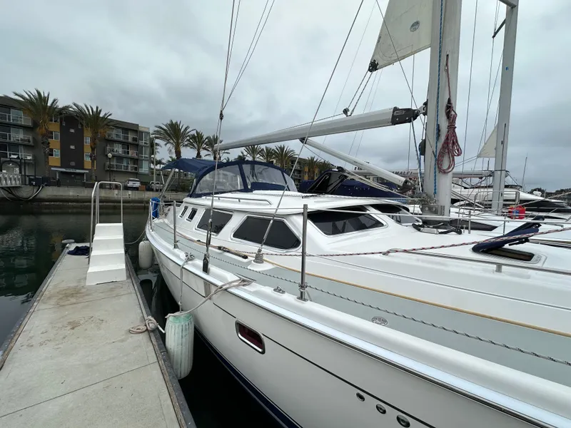 Slide: The Image of 2007 Hunter 44 Deck Salon sailboat docked at marina, overcast sky. - 9