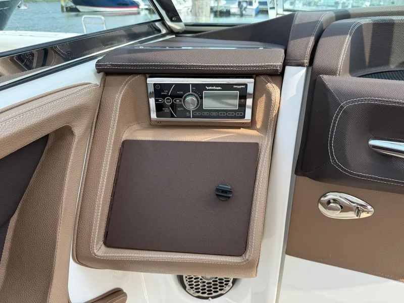 Slide: The Image of Cobalt 302 boat interior with stereo system, brown leather accents, and chrome handle, 2015 model. - 14