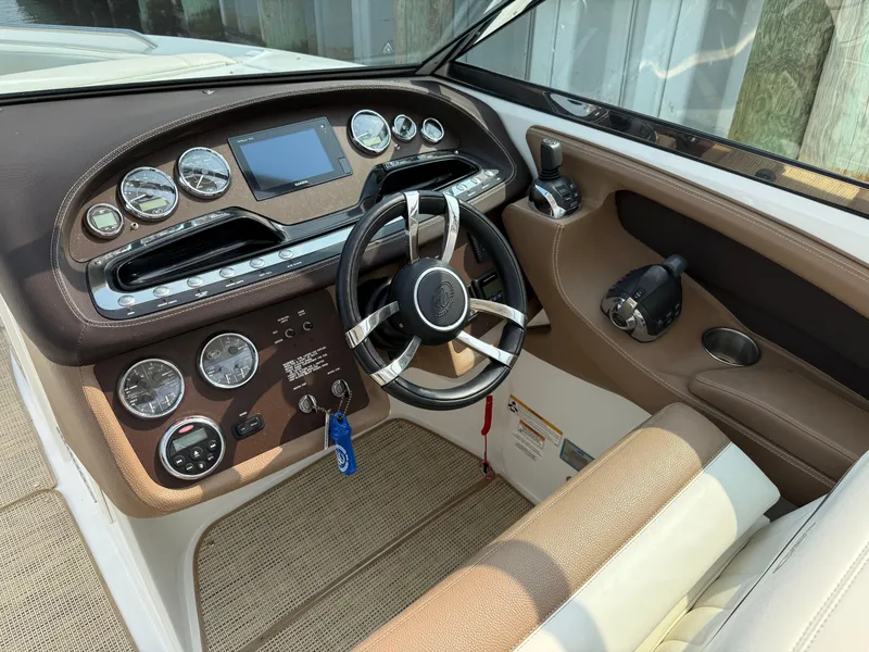 Slide: The Image of Interior of a 2015 Cobalt 302 boat showing steering wheel and dashboard controls. - 16
