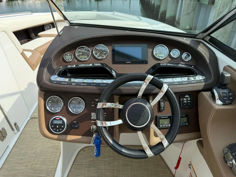 Slide: The Image of 2015 Cobalt 302 boat dashboard with steering wheel and control panel. - 17