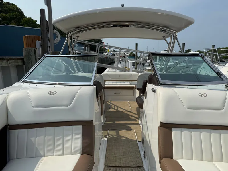 Slide: The Image of 2015 Cobalt 302 boat interior with white and brown seating, docked at marina. - 21