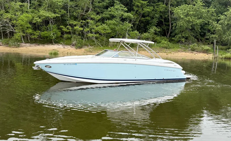 Slide: The Image of 2015 Cobalt 302 boat on calm water near a forested shoreline. - 4