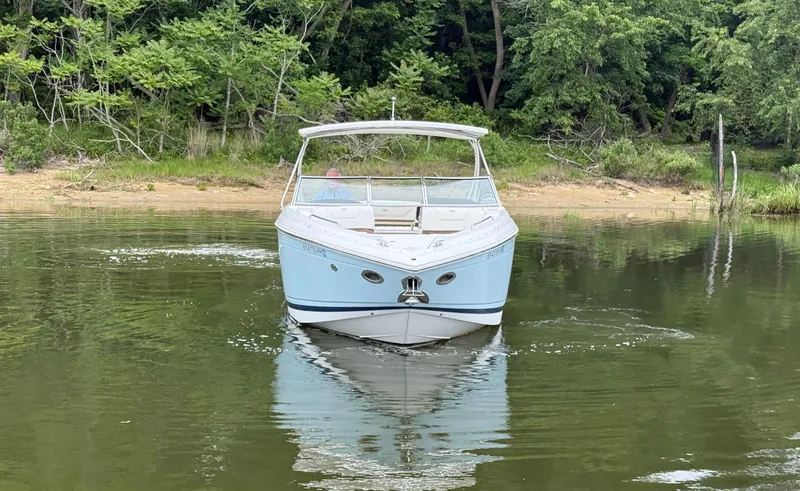 Slide: The Image of 2015 Cobalt 302 boat on calm water near a forested shoreline. - 6