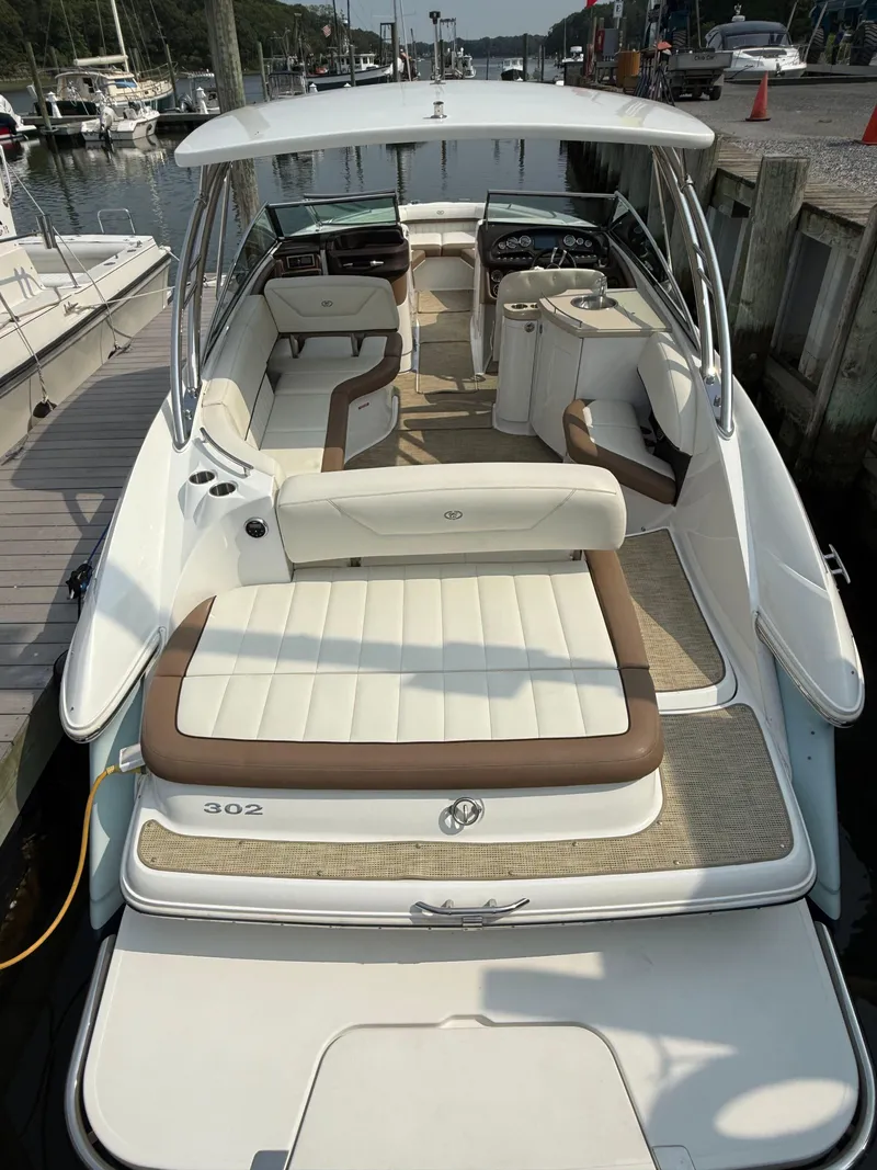 Slide: The Image of 2015 Cobalt 302 boat with spacious seating, docked at a marina. - 8
