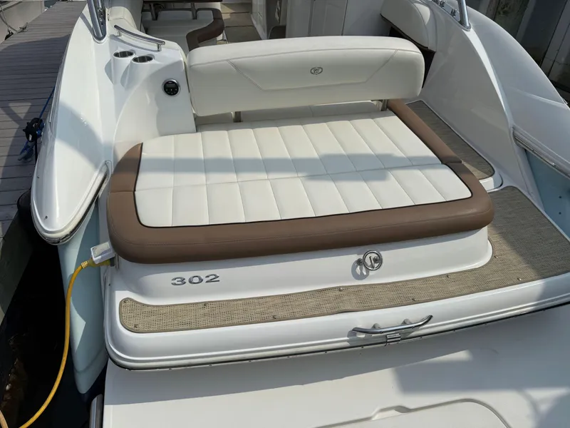 Slide: The Image of 2015 Cobalt 302 boat with white and brown seating, docked at marina. - 9
