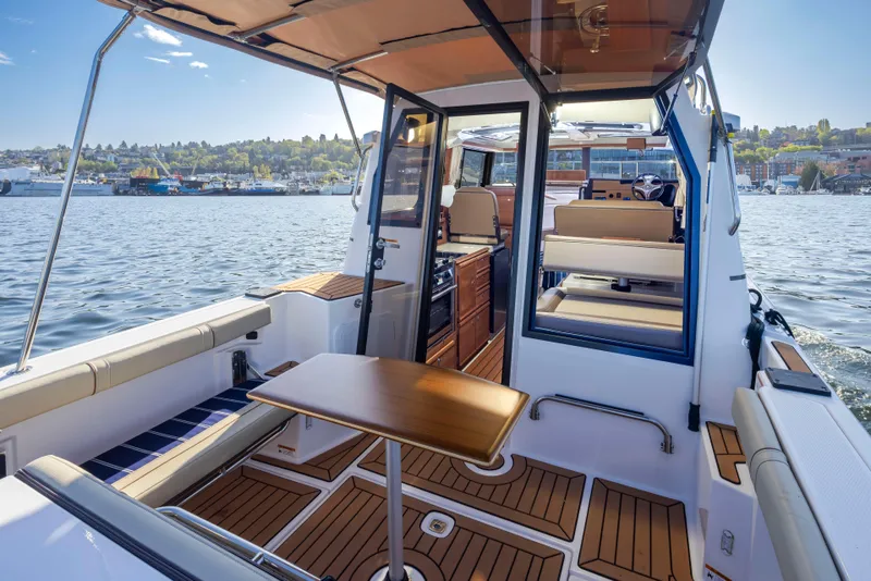 Slide: The Image of 2020 Ranger Tugs R-27 boat interior with wood accents, docked on a sunny day. - 11
