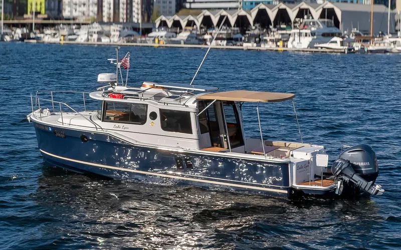 Slide: The Image of 2020 Ranger Tugs R-27 boat on water, cityscape background, sunny day. - 13