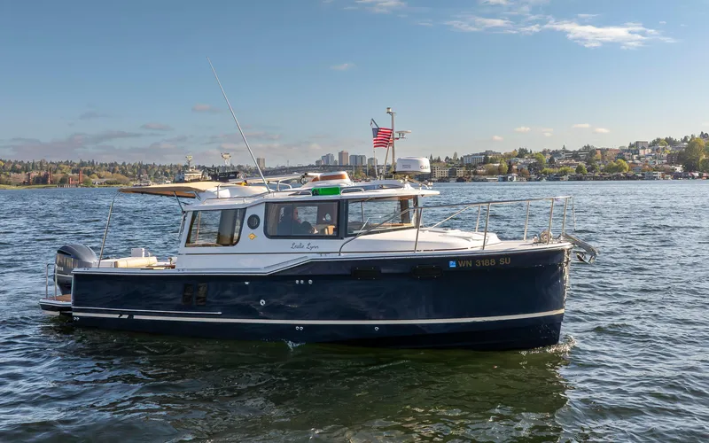 Slide: The Image of 2020 Ranger Tugs R-27 boat on a sunny day, cruising on a scenic lake. - 15