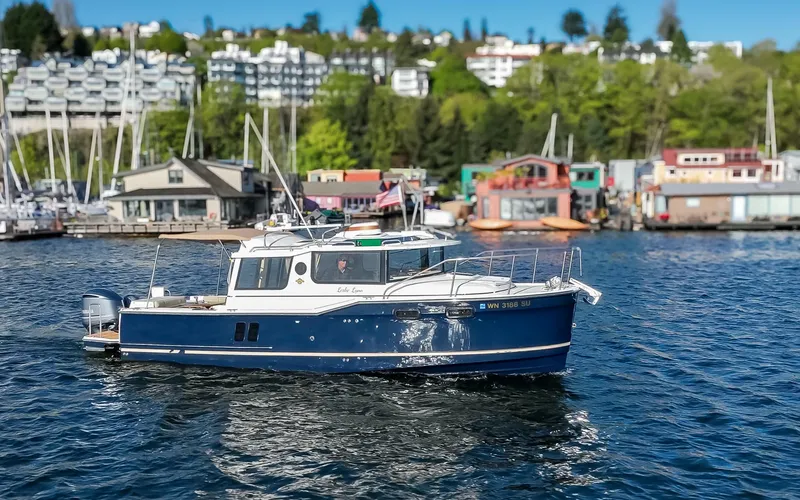 Slide: The Image of 2020 Ranger Tugs R-27 boat on a scenic waterfront with colorful buildings. - 19