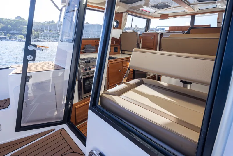 Slide: The Image of Interior view of 2020 Ranger Tugs R-27 boat with seating and wooden cabinetry. - 28