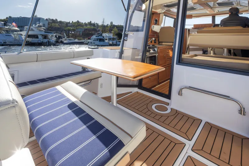 Slide: The Image of 2020 Ranger Tugs R-27 boat interior with seating, table, and wood flooring. - 30