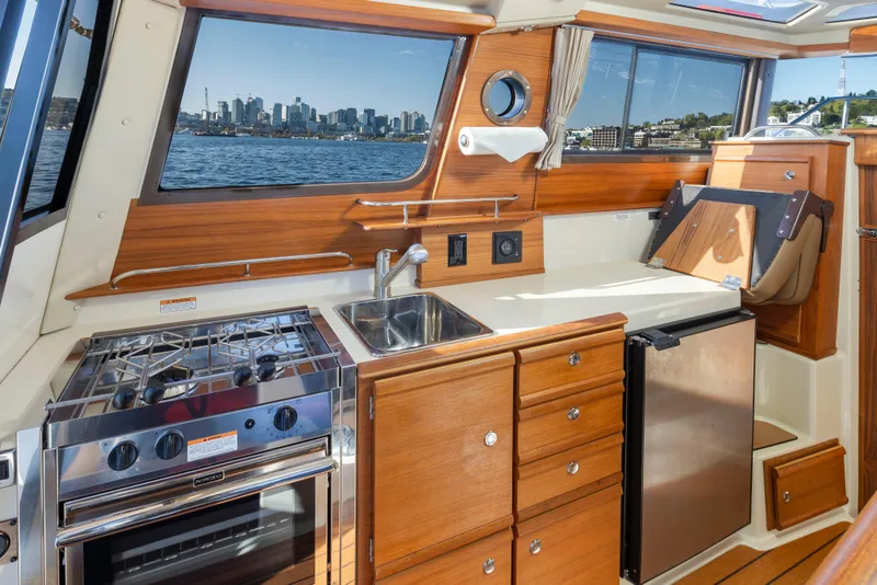 Slide: The Image of Interior of 2020 Ranger Tugs R-27 boat with kitchen and scenic window view. - 9