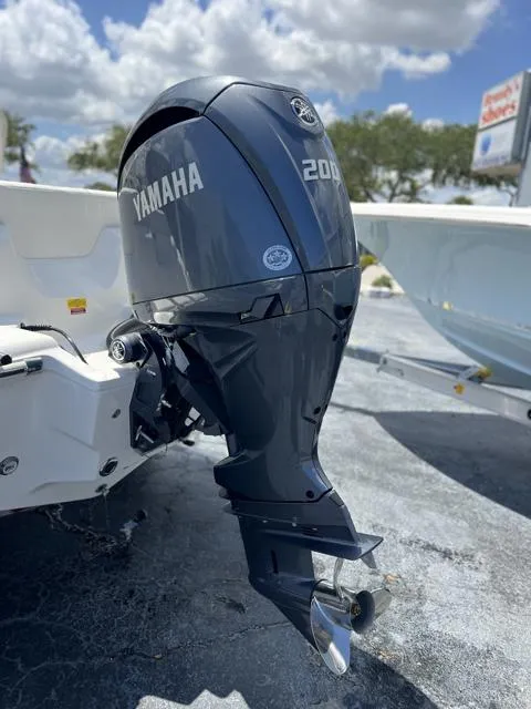Slide: The Image of 2025 Key West 219 FS boat with Yamaha 200 outboard motor, parked outdoors. - 11