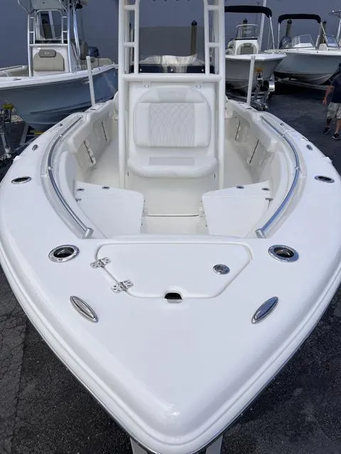 Slide: The Image of 2025 Key West 219 FS boat, white interior, spacious seating, sleek design, docked outdoors. - 13