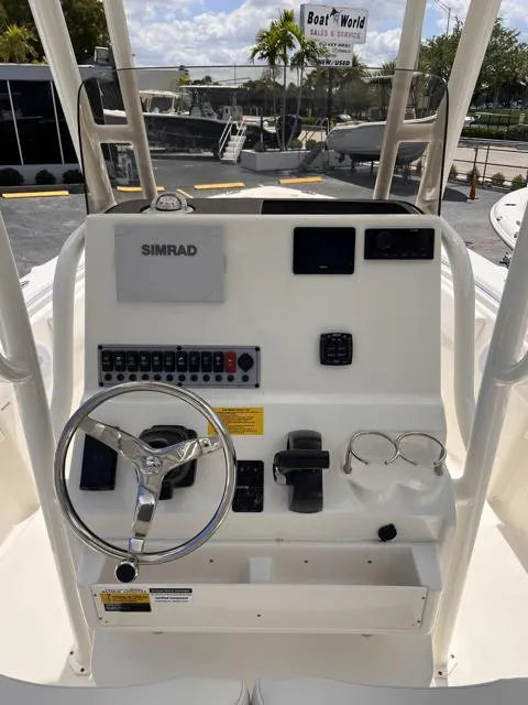 Slide: The Image of 2025 Key West 219 FS boat console with steering wheel, Simrad display, and control panel. - 15