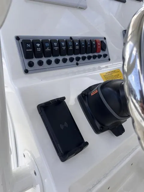 Slide: The Image of 2025 Key West 219 FS boat dashboard with control panel and wireless charging pad. - 19