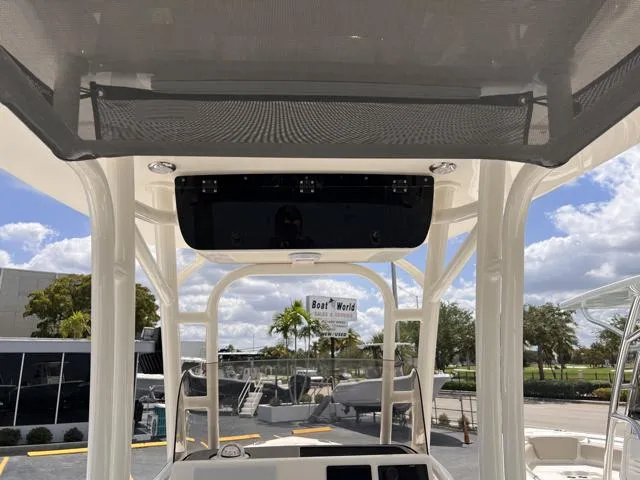 Slide: The Image of 2025 Key West 219 FS boat console with canopy, displayed at Boat World under a sunny sky. - 23