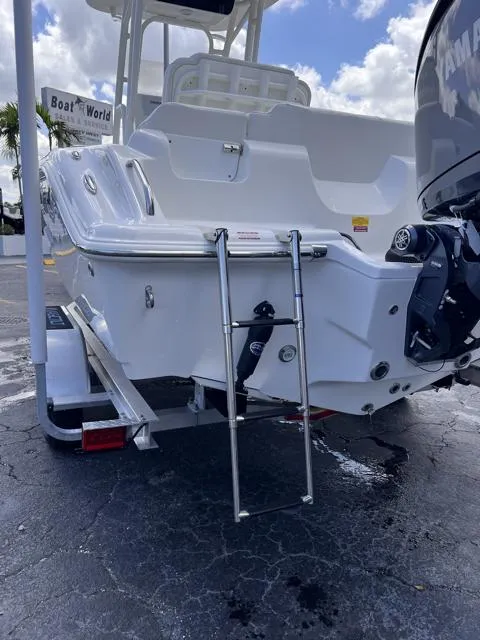 Slide: The Image of 2025 Key West 219 FS boat with ladder and motor, parked on a trailer. - 35