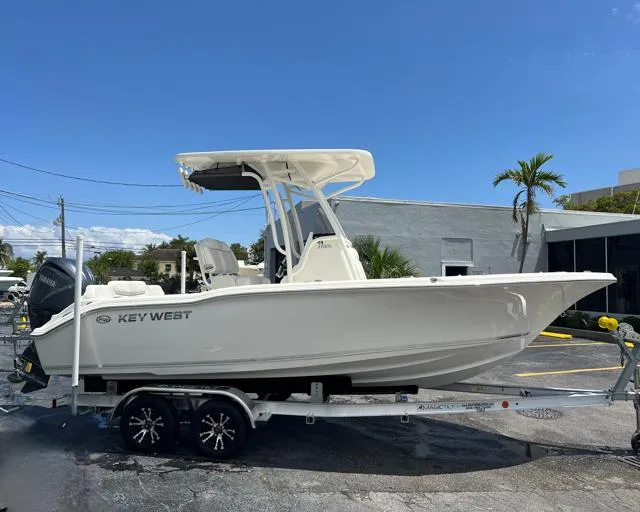 The Image of 2025 Key West 219 FS boat on trailer, parked outdoors under clear blue sky. - 7